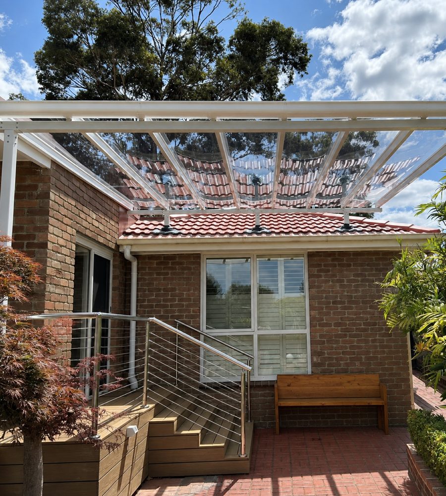 Pergola with a clear roof panel and climbing plants